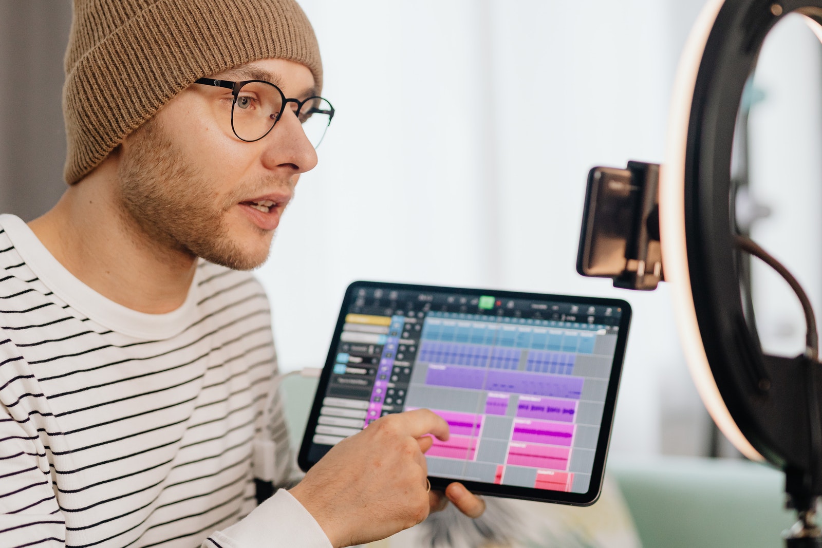 Man in White and Black Striped Crew Neck Shirt Holding Black Tablet Computer